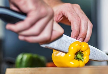 Pimiento amarillo siendo cortado para rellenar en un asado vegetariano 