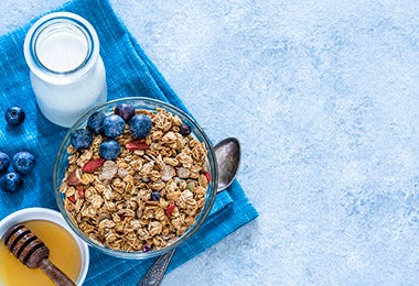 Bowl con granola, fruta, leche y miel en desayuno continental