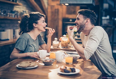 Pareja comiendo sándwiches, uno de los desayunos fáciles y rápidos