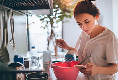 Mujer preparando galletitas fáciles mirando receta 