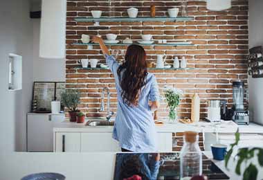 Una mujer ordenando los estantes de su cocina