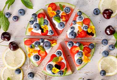    Una pizza frutal decorada con flores comestibles          