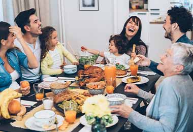   Una familia disfrutando de una cena con guarniciones navideñas   