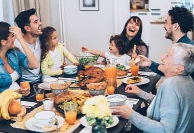   Una familia disfrutando de una cena con guarniciones navideñas.  