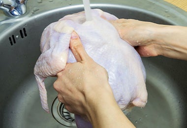Un pollo entero siendo lavado con agua. Un pollo entero siendo lavado con agua.