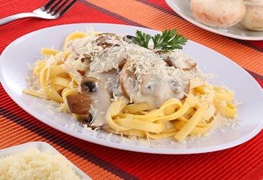 Plato de recetas con tallarines con salsa de champiñones Plato de recetas con tallarines con salsa de champiñones