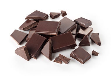 Trozos de chocolate en tabla moldes para chocolate Trozos de chocolate en tabla moldes para chocolate