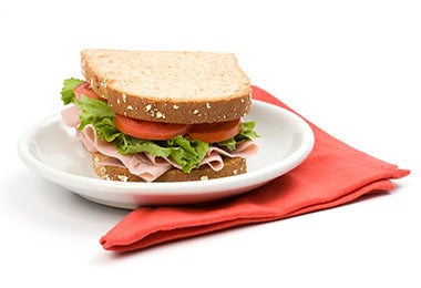 Cómo preparar un sándwich relleno jamón, tomate y lechuga plato y servilleta Cómo preparar un sándwich relleno jamón, tomate y lechuga plato y servilleta