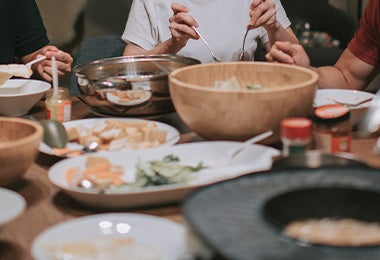 Familia compartiendo dumplings y otros platillos asiáticos Familia compartiendo dumplings y otros platillos asiáticos
