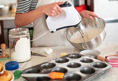 Mujer batiendo ingredientes con bicarbonato de sodio para cocinar Mujer batiendo ingredientes con bicarbonato de sodio para cocinar