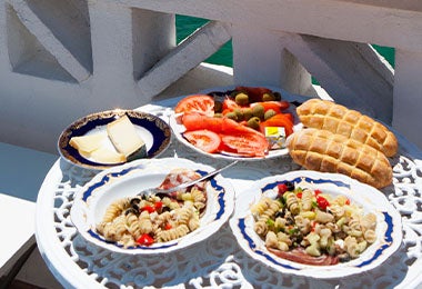 El turismo gastronómico es popular en todos los continentes. Una mesa con dos platos servidos y con vista al mar, una posibilidad del turismo gastronómico.