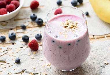 Vaso con batido de frutos rojos para beber antes de hacer ejercicio Vaso con batido de frutos rojos para beber antes de hacer ejercicio