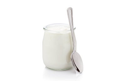 El yogurt griego es reconocido en la cocina mediterránea Recipiente de vidrio con yogurt griego y cuchara