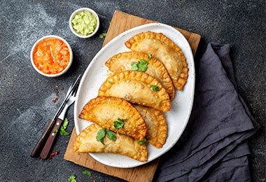 Comida tapa: empanaditas en un plato con salsa.&nbsp;
