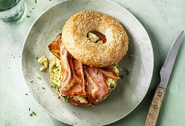 Desayuno con pan bagel de panceta y huevo