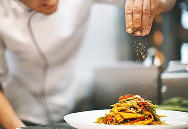 chef añadiendo especias exóticas a un plato