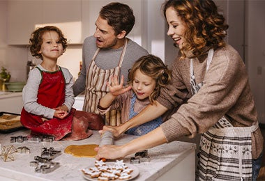 Familia decorando galletitas de árbol de navidad