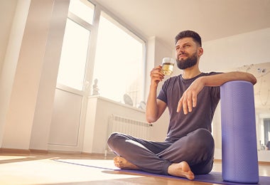 Hombre después de practicar yoga en casa con un té de cúrcuma y jengibre.