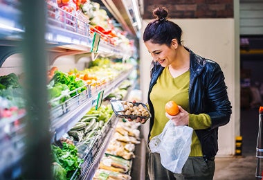 Una mujer comprando alimentos balanceados por su autocuidado