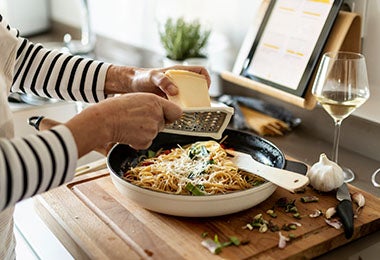 Mujer rallando queso parmesano en receta de pasta