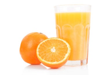 Dos naranjas y un jugo de naranja, una de las frutas con más vitaminas y nutrientes