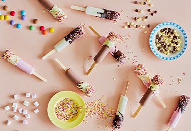 Recipiente con cake pops en una mesa de dulces
