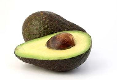Palta cortada a la mitad para incluirla en la hamburguesa de pescado.