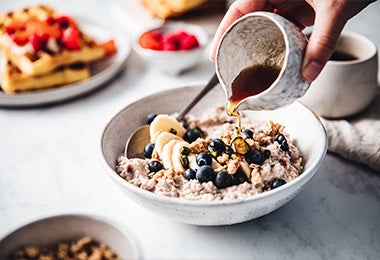Plato de porridge con banana, arándanos y miel 