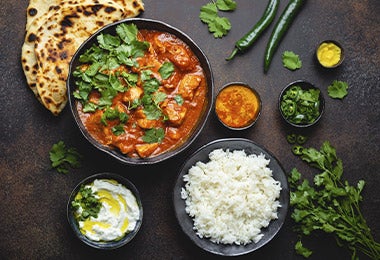 Receta de curry rojo con pollo, arroz, pimientos y pita en una toma cenital