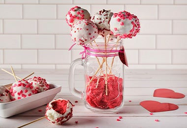 Cake pops en vaso decorando una mesa de dulces y postres 