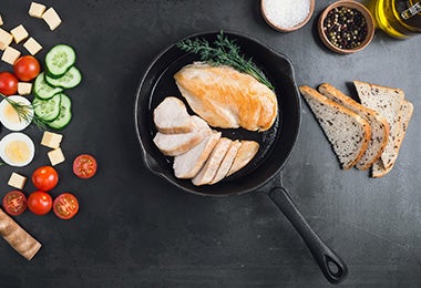 Pechuga de pollo con verduras, preparada en una sartén de hierro. 