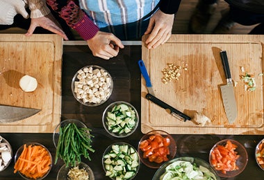 Tabla de corte con cuchillos y verduras cortadas