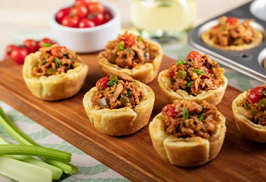 Tapas españolas con pimientos, carne y verduras en una tabla de madera.  