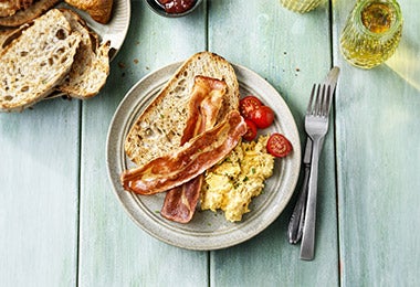 Tocino, pan y huevos revueltos en plano cenital, uno de los desayunos fáciles y rápidos que recomendamos