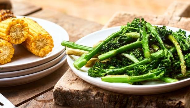 Choclos y espárragos sobre una mesa de madera en un asado vegetariano 