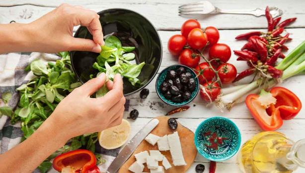 Una persona preparando una ensalada navideña, deliciosa y colorida. 