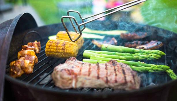 Asado de carne y vegetales, con pinzas para darles vuelta, un utensilio muy importante.