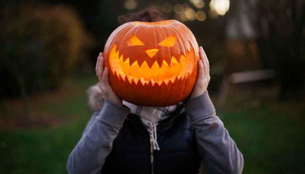 Calabaza de Halloween sobre el cuerpo de una persona.  