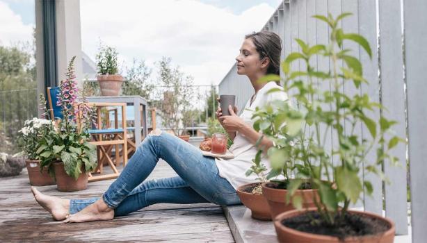 Una mujer con un vaso y un plato de comida aprovechando un buen descanso