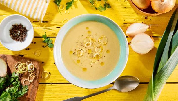Vichyssoise en un bowl, mesa amarilla con ingredientes frescos