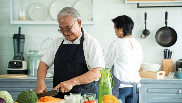 Hombre cortando zanahoria con técnica.
