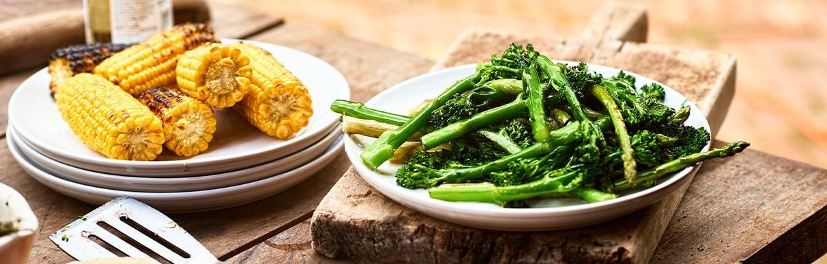 Choclos y espárragos sobre una mesa de madera en un asado vegetariano 