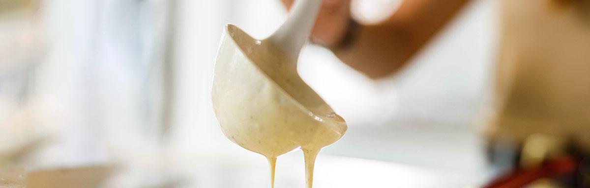 Una mujer preparando pancakes con un cucharón 