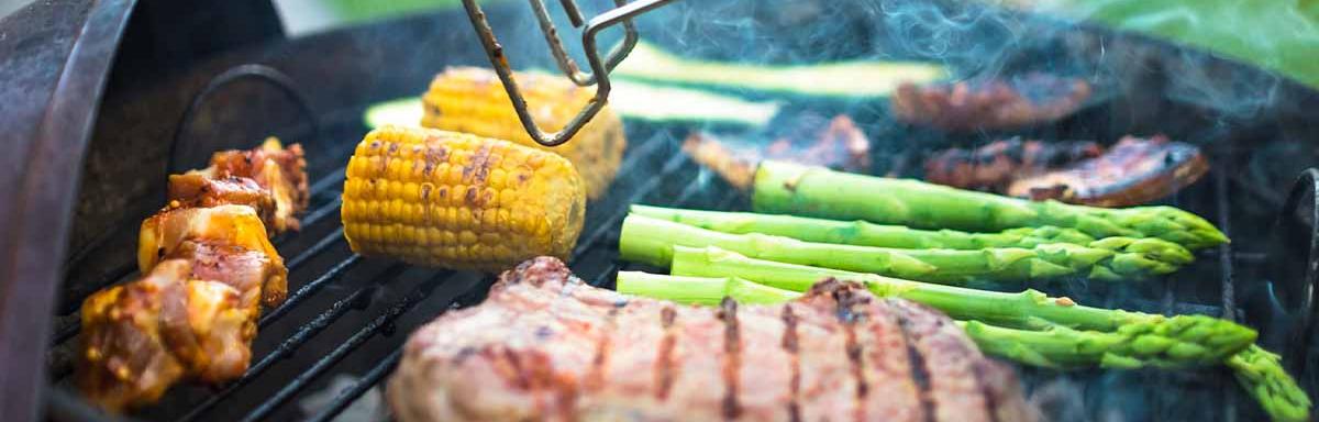 Asado de carne y vegetales, con pinzas para darles vuelta, un utensilio muy importante.