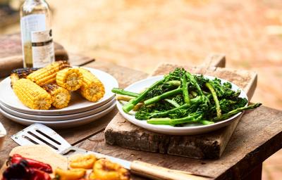 Choclos y espárragos sobre una mesa de madera en un asado vegetariano 