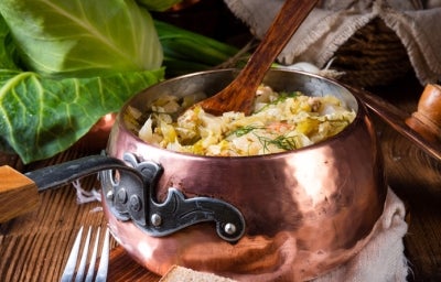Olla con sopa y cuchara de palo 