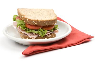 Un sándwich clásico de jamón, lechuga y tomate, uno de los snacks saludables más populares Un sándwich clásico de jamón, lechuga y tomate, uno de los snacks saludables más populares