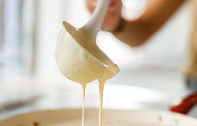 Una mujer preparando pancakes con un cucharón 