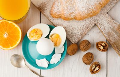 Huevos cocidos, acompañados por jugo de naranja y un croissant. Huevos cocidos, acompañados por jugo de naranja y un croissant.