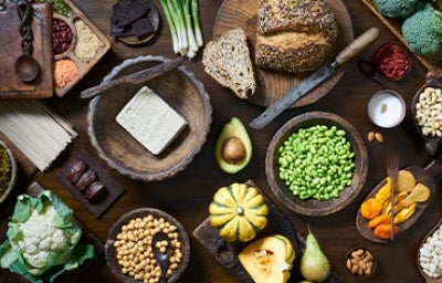 Tofu, granos, semillas y verduras servidas en una mesa, comidas veganas que se suelen usar.